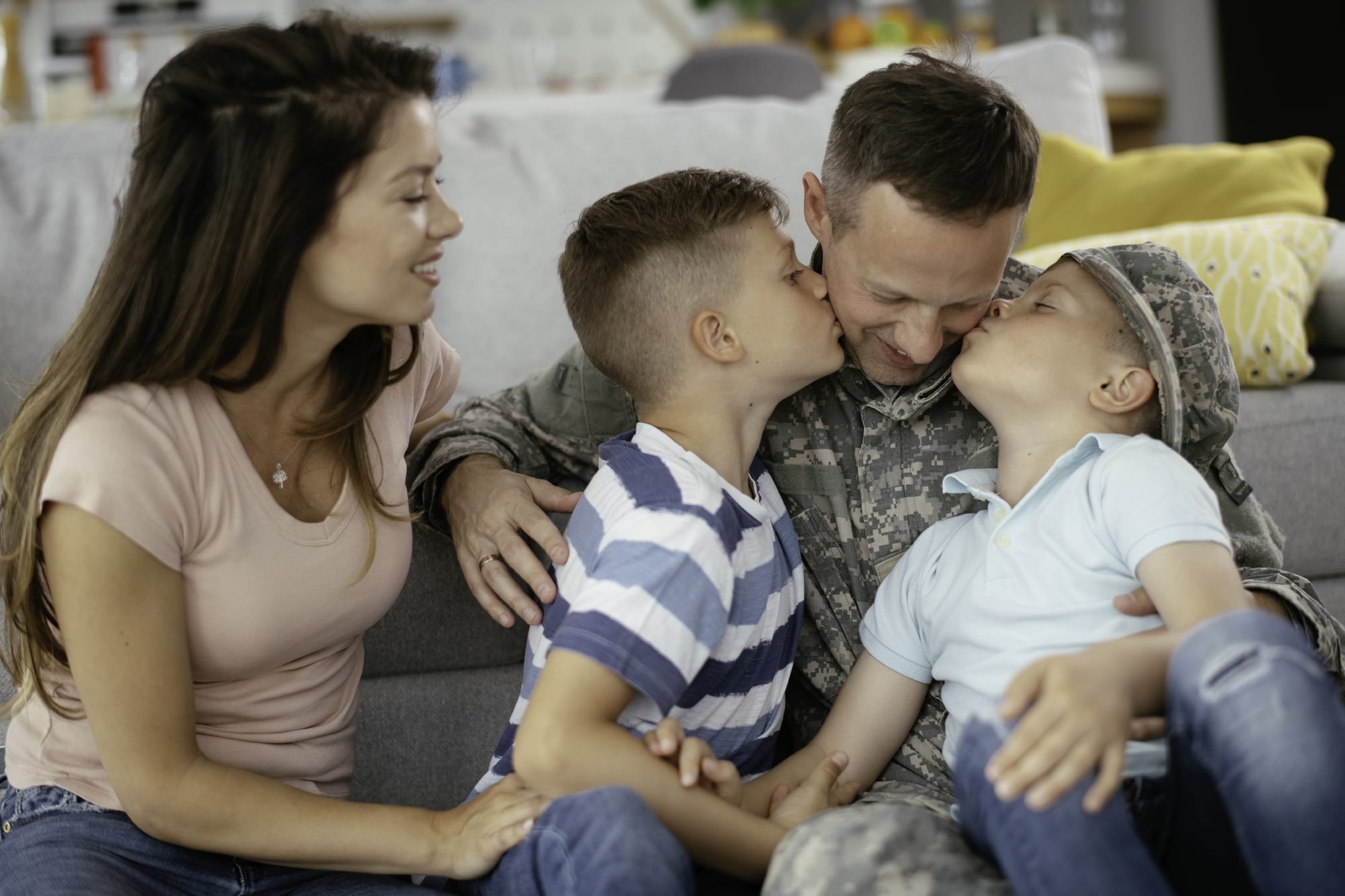 Photo of a veteran father on the couch with his two sons and his wife